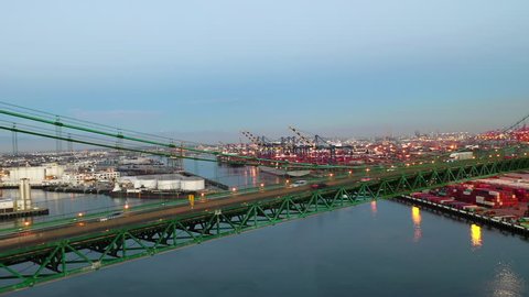 Aerial Pan Left: Green Bridge Bustling In Evening With Blue Sky Above in Long Beach, United States of America