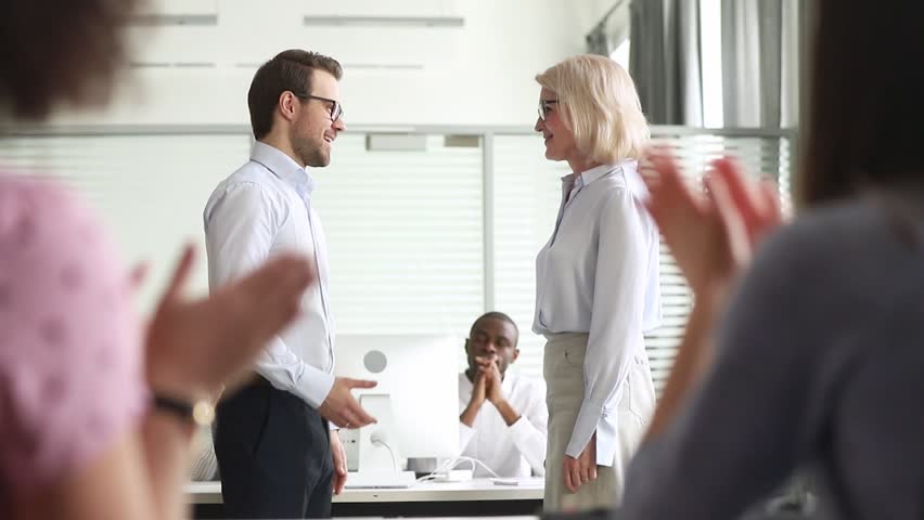 Happy manager boss praise old female employee for great professional achievement handshake loyalty member get team applause appreciation, proud mature worker promoted rewarded with respect handshake Royalty-Free Stock Footage #1029051383