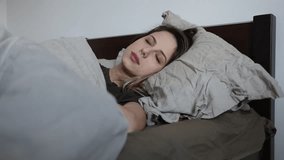 Young woman slipping in a bed a can not to wake up even with alarm 