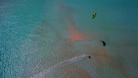 aerial follow of a lone kitesurfer in a prime tropical location 