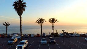 Aerial drone footage of Dana Point California over the coastline at sunset. Beautiful waves crashing as the sun is setting over the beach.