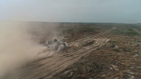 Aerial View Military Army Tank Shooting. Heavy Combat Fighting Vehicle Training in Sand Back View. Battlefield Advanced Technology/ Drone Shot Footage 4K (UHD)