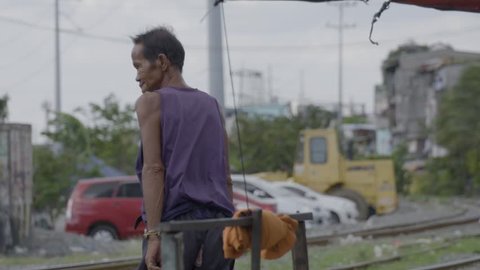 MANILA, PHILIPPINES - CIRCA JANUARY 2017: A poor old man crossing the railroad in Manila