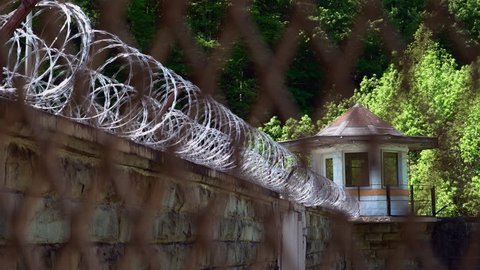 View of guard tower and razor wire at a prison or jail through the prison fencing.