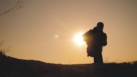 teamwork business travel concept. legs silhouette group hikers of people walking on the top of the mountain with backpacks sunset sun light. slow motion video. campaign tourists with backpacks