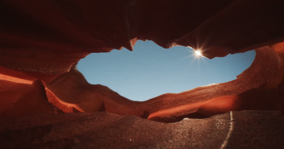 Beautiful view of a canyon cave showing a sunbeam and a blue sky, 4k Royalty-Free Stock Footage #1029125075
