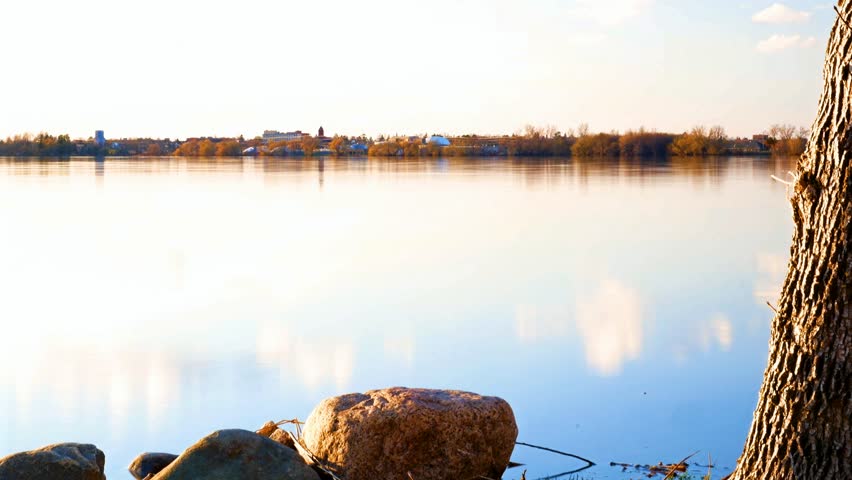 Bemidji, Minnesota, the 2018 Best Town in Minnesota is seen at sunset across Lake Irving, the first lake on the Mississippi River, in a time-lapse clip with zoom and tilt.