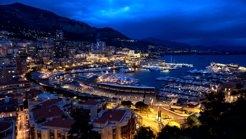Timelapse of Monaco Monte Carlo harbour and city skyline in the evening. Monaco Port night view with fast moving clouds