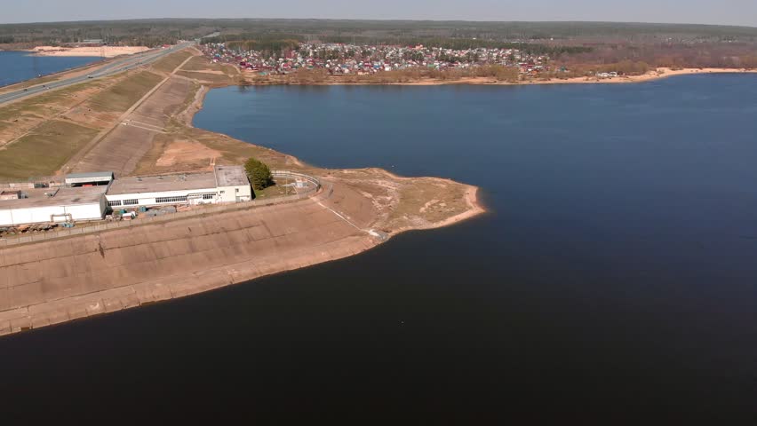 flight over hydro power station on a river in sunny weather, aerial filming from a copter