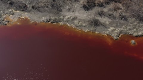 Red polluted water from open pit mining site 4K drone video
