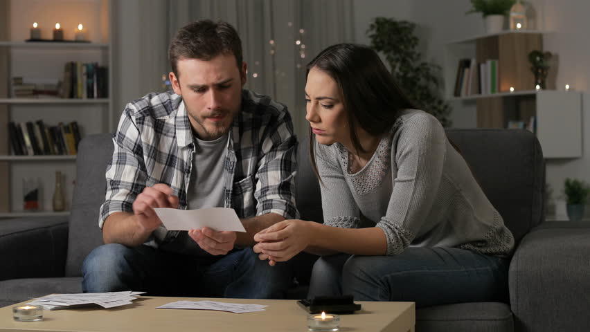 Preoccupied couple accounting checking receipts sitting on a couch in the night at home Royalty-Free Stock Footage #1029150869