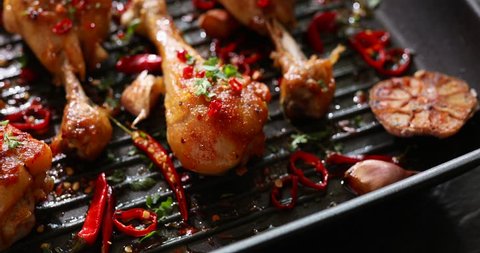Grilled chicken. Spicy Grilled chicken legs, drumsticks with addition chili pepper, garlic and herbs on grill plate. Grill food, 4K