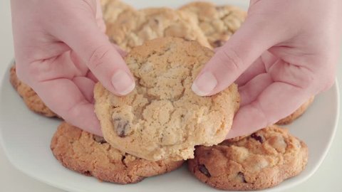 Woman breaking chocolate chip cookie in half, Close Up on Hands, Slow Motion
