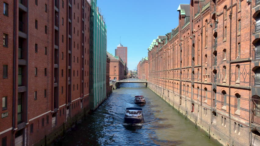 Scenic real time panorama footage of tourist ships riding on canal through famous historical Speicherstadt district on a beautiful sunny summer day in Hamburg, northern Germany, Europe