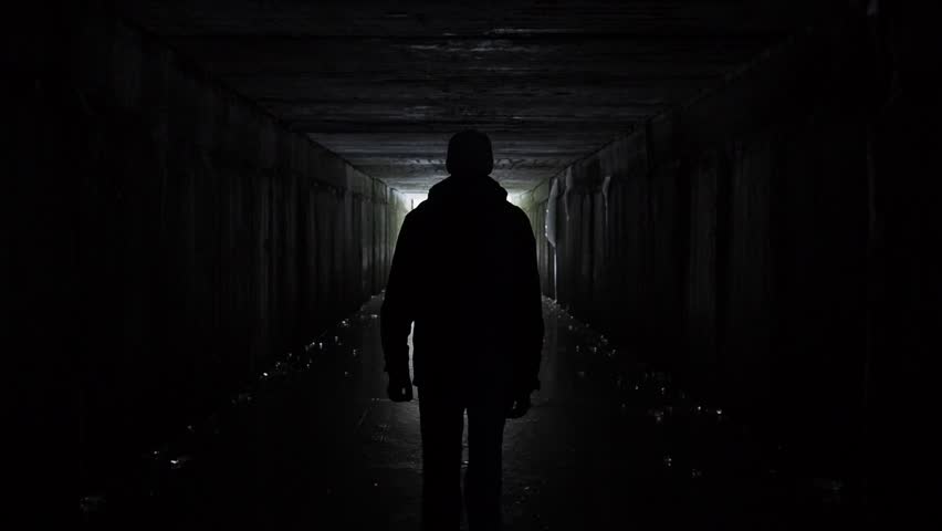 Man silhouette walking in a dark tunnel. Underground, post apocalyptic view. Exit and depression concept. People authentic video. Depression caused by coronavirus, quarantine, COVID 19. Human health  | Shutterstock HD Video #1029169520