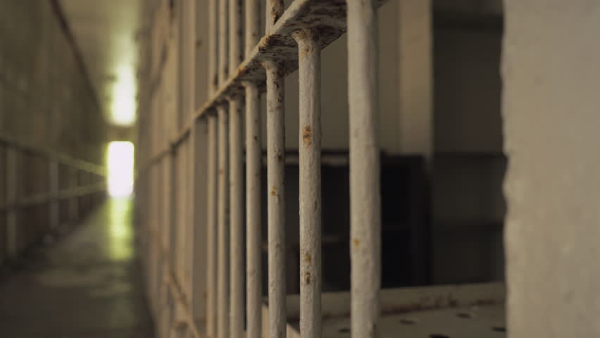 Panning shot of prison walkway in front of prisoner cell. Royalty-Free Stock Footage #1029169607