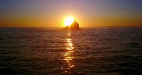 Lighthouse Sunset on Isolated Rocky Island in Pacific Ocean - Tillamook Rock, Oregon, USA - Reverse Panning Shot