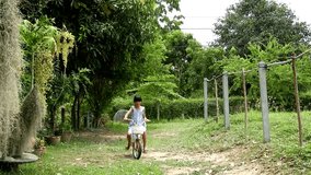  Out of focus girl riding bicycle in garden,asian young girl riding bicycle alone in garden