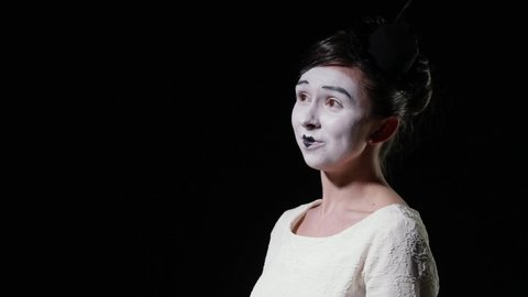 mime woman in white dress emotionally shouts at someone
