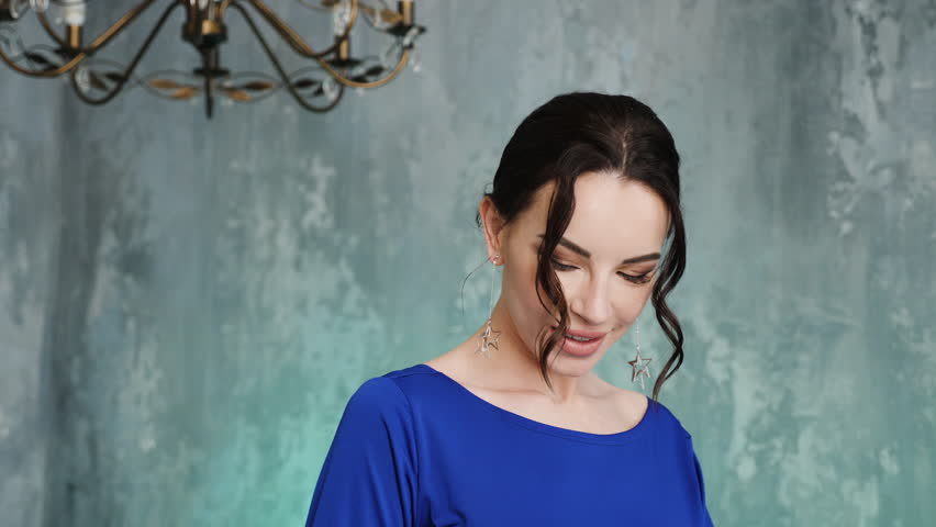 stylish sexy young girl model stands in a long blue dress in the Studio