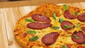 Appetizing hot pepperoni pizza lies on a tray. Appetizing hot pepperoni pizza lies on a tray. Close-up. 4k