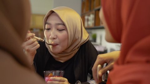 hijab women enjoy sweet drink when breaking fast together at home