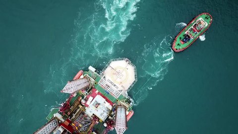 ISTANBUL - CIRCA 2018: Top down view of The GSP Saturn oil platform towing through the Bosphorus Strait. Aerial of tugboats maneuver the offshore drilling rig. Oil drilling platform being towed in cha
