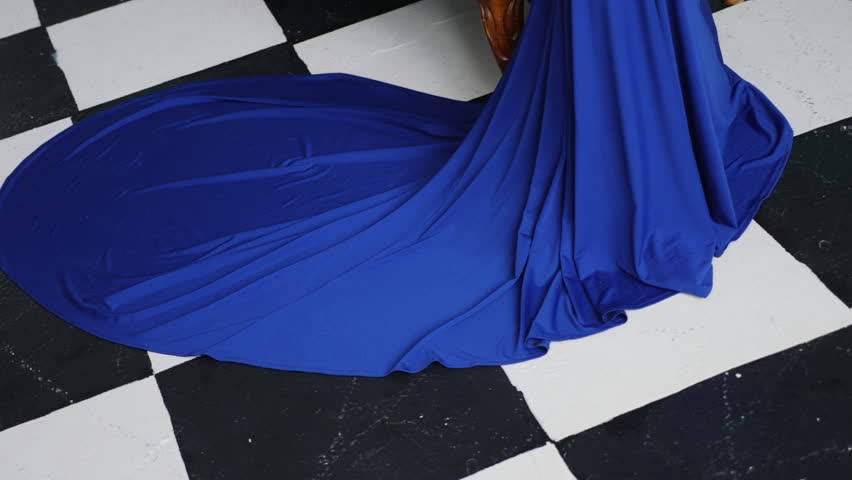 stylish sexy young girl model stands in a long blue dress in the Studio