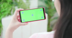 woman use smart phone with green screen at home