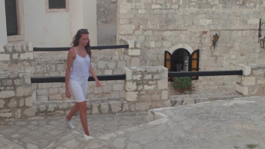 Girl walking in ancient fortress towards an amazing viewpoint of the whole city of Hvar