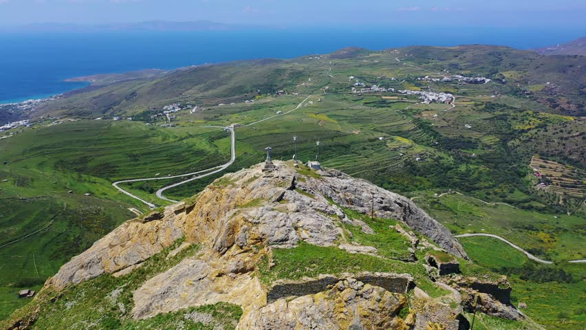Aerial drone video of iconic mountain and castle of Exomvourgo or Exombourgo with breathtaking views to the Aegean, Tinos island, Cyclades, Greece