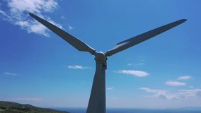 Aerial drone closeup video of wind turbine propeller blades rotating as seen in Aegean island of Tinos at spring, Cyclades, Greece