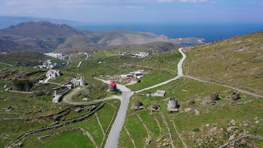 Aerial drone video of iconic monastery of Panagia Katapoliani and picturesque windmills in road to Isternia village, Tinos island, Greece