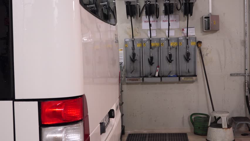  A woman service worker checking oil level in a bus, workshop woman portrait, bus repair service.