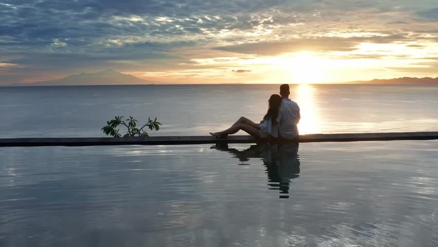 Couple In Love At Luxury Resort On Romantic Summer Vacation. People Relaxing Together In Edge Swimming Pool , Enjoying Beautiful sunset Sea View. Happy Lovers On Honeymoon Travel. Relationship | Shutterstock HD Video #1029229823