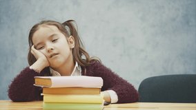 A little schoolgirl sleeps at the table with a lot of books. Many homework or examinations are stressful for young children. Heavy school program. - Powered by Shutterstock - Get 15% off with code: PIKWIZARD15