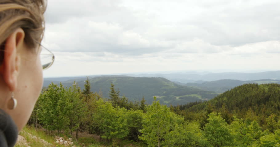 Female hiker shielding eyes with hand while admiring Black Forest, Baden-Wurttemberg, Germany