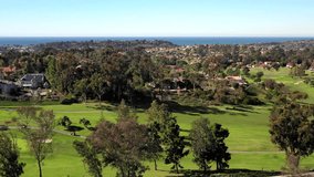 Aerial drone video over a golf course in Solana Beach, California, with the Pacific Ocean in in the horizon.