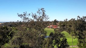 Aerial drone video over a golf course in Solana Beach, California, with the blue Pacific Ocean in the horizon.