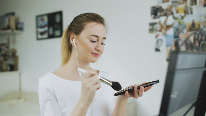 Woman With Beauty Face Applying Makeup and listen music