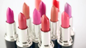 Lipstick. Fashion Colorful Lipsticks rotated over white background. Lipstick tints palette, Professional Makeup and Beauty. Beautiful Make-up concept. Lipgloss. Lipsticks closeup. UHD 4K video
