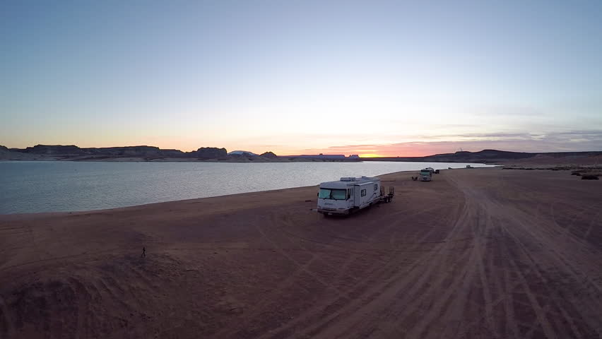 Aerial shot rising over the stunning Lake Powell at sunset, with RV