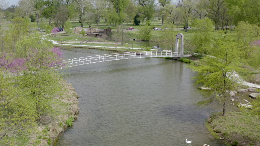 Aerial drone flight over a walking bridge over water