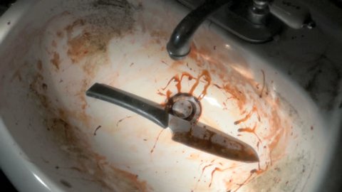 Bloody knife is dropped into dirty old sink, horror or murder concept 