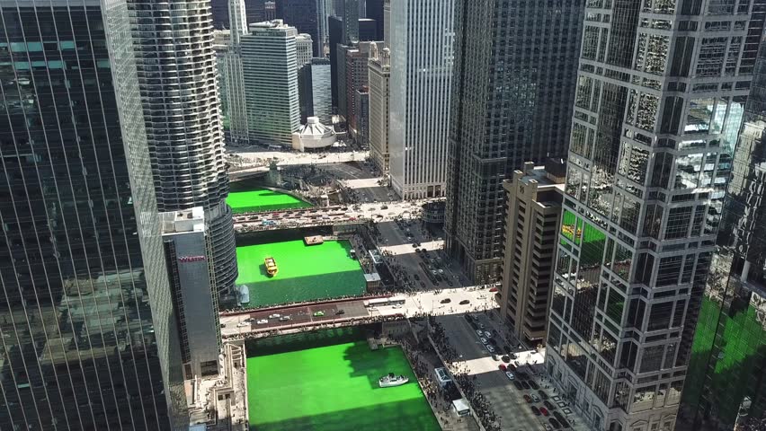 AERIAL: extremely slow angled down push through the buildings of the city of Chicago, Illinois during the St. Patrick