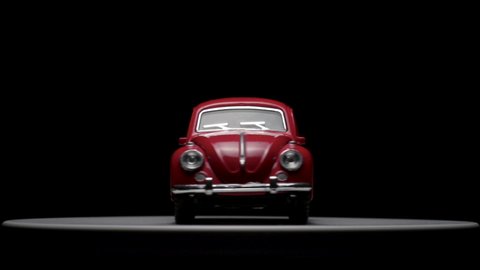 Izmir, Turkey - May 11, 2019. Rotating Red Volkswagen Beetle Toy car on a black background.