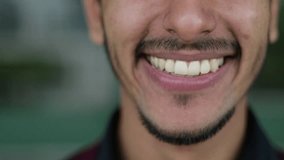 Close up shot of handsome young mixed-race mans mouth looking at camera, smiling. Lifestyle concept 