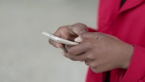 Close up shot of Afro-american young female hands with gold rings texting on phone. Side view. Communication, lifestyle concept