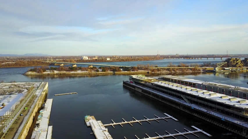 Cinematic drone - aerial footage moving fowards and descending showing the docks at the Old Port (Vieux Port) of Montreal the south shore (rive sud) during winter season.