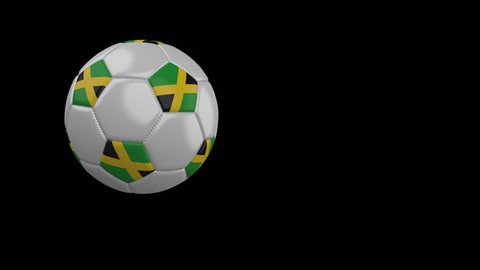 Soccer ball with the flag of Jamaica flies past the camera, slow motion, 4k footage with alpha channel
